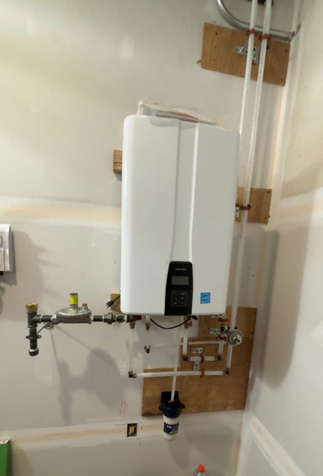 Wall-mounted tankless water heater with gas and water lines